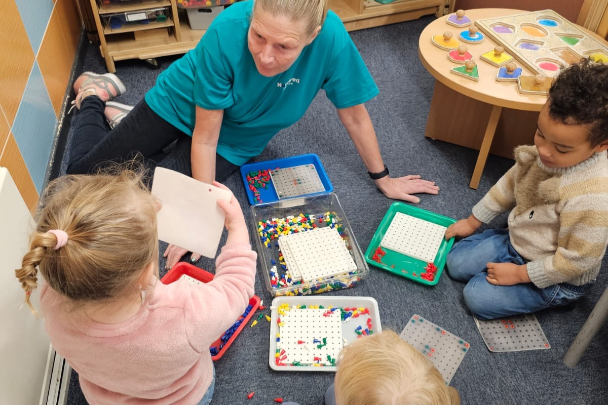 Children learning with an early years practitioner at Nurtured @ Balby nursery